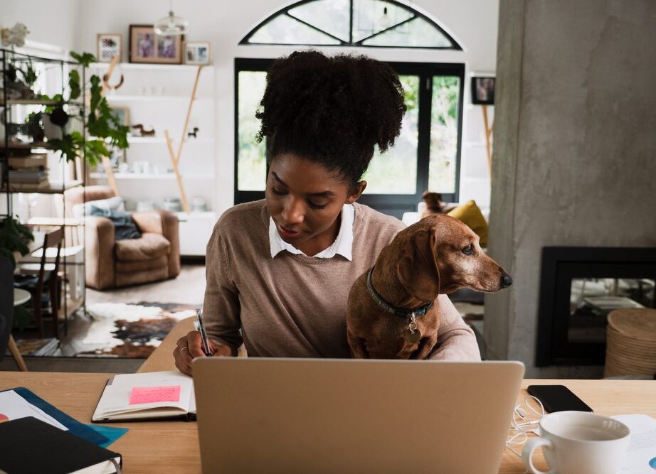 woman with dog taking notes at the computer