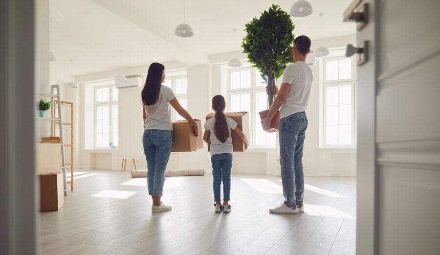 mother, father, daughter in empty new home