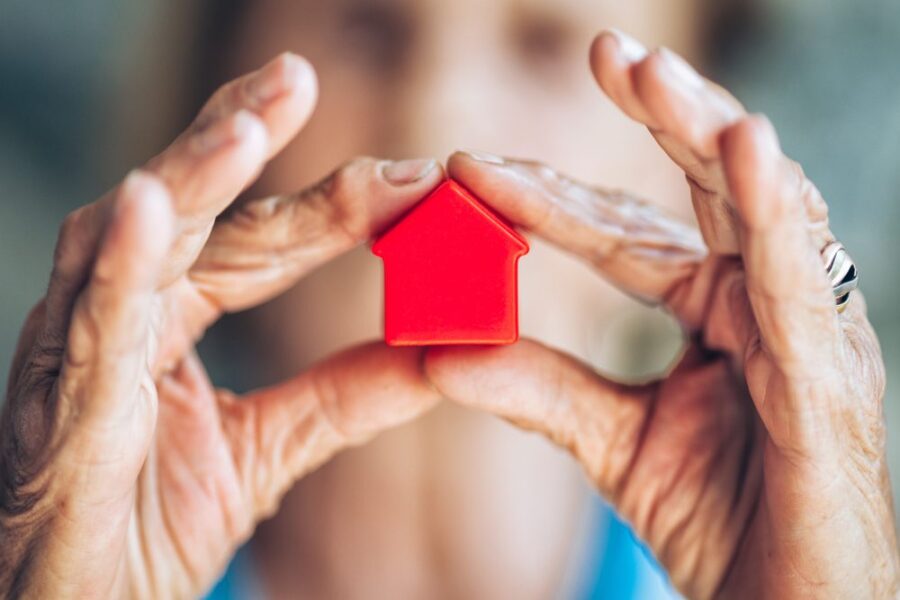 closeup hands with miniature house