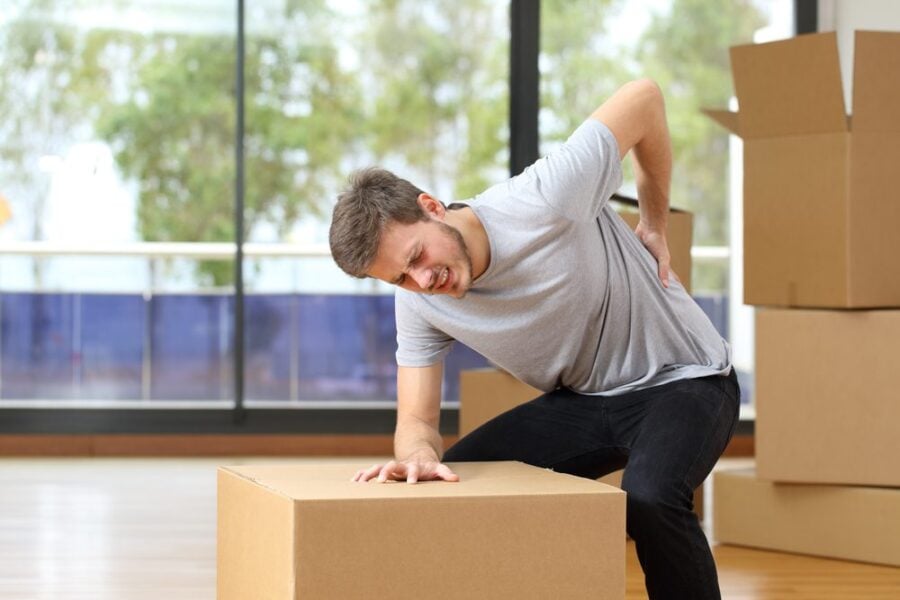 man with back pain and moving boxes