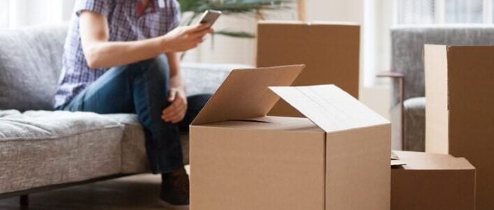 closeup of boxes and man on the phone