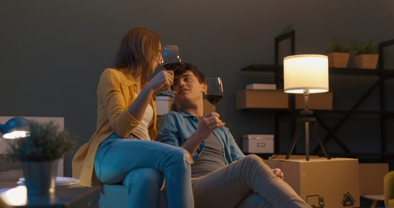 couple toasting with wine surrounded by moving boxes