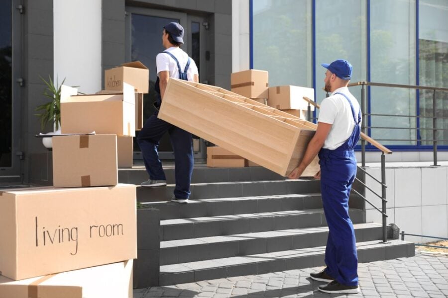 moving men carrying book case up stairs
