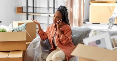 woman on the phone surrounded by moving boxes