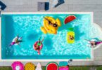 aerial view of home swimming pool with people floating on pool floats