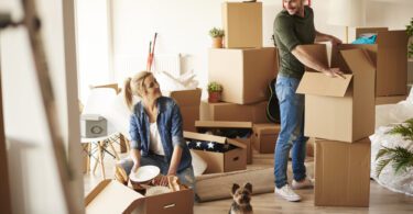 couple unpacking moving boxes in their home
